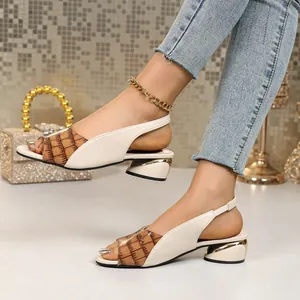 Side view detail of cream and brown crocodile pattern slingback block heel sandals