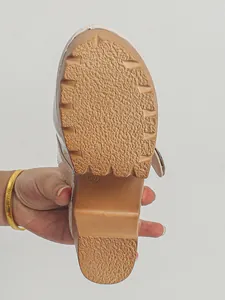Detailed view of the anti-slip textured sole and wood-style platform of women's clogs
