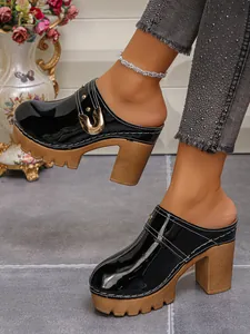 Detailed side view of black patent leather platform high heel mules with rivet buckle