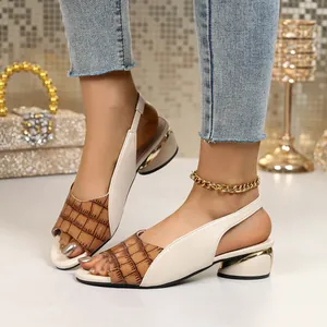 Detail view of stylish mixed-color peep-toe sandals with chunky gold-accented heels