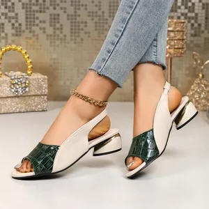 Detail shot of two-tone block heel peep-toe sandals with green croc-embossed texture