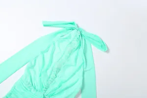 Close-up of mint green mesh dress showing halter neck tie and pleated detail