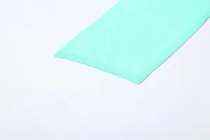 Close-up detail of mint green mesh stitching and pleated texture of the dress