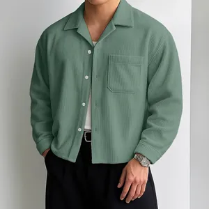 Detail van groen corduroy herenoverhemd met verlaagde schouders en borstzakje.