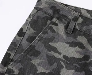 Close-up detail of camouflage cargo trousers showing waistline and pocket structure