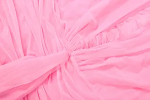 Detail close-up of pink mesh fabric with elegant pleated texture on a women's dress