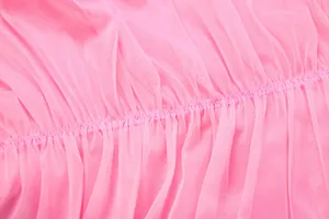 Close-up of pink mesh fabric detailing the pleated stitching of the halter dress.
