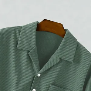 Detailopname van herenoverhemd van corduroy in saliegroen met reverskraag en textuur