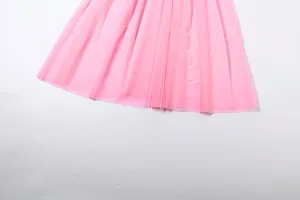 Detailed view showing the fine texture of the pink pleated mesh hemline for a dress.