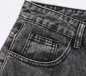 Detailed close-up view of the waistband and pocket on washed black denim pants
