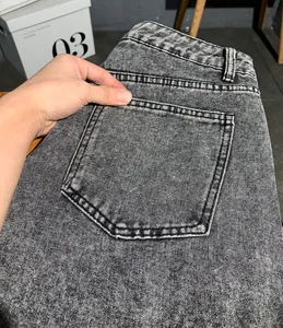 Gros plan sur le détail de la poche arrière d'un jean cargo en denim noir délavé