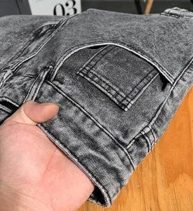 Gros plan détaillé du denim gris délavé à l'acide et des coutures de ce pantalon cargo