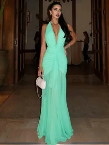 Elegant mint green halter neck pleated maxi dress with deep V-neckline and flowy skirt