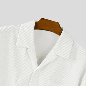 Detailopname van de kraag en textuur van een wit corduroy overhemd met borstzak