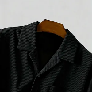 Detailopname van zwart corduroy overhemd met inkepingkraag en textuur
