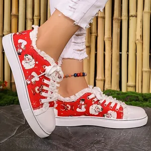 Close-up detail of festive red Christmas canvas sneakers with Santa Claus print worn by a model