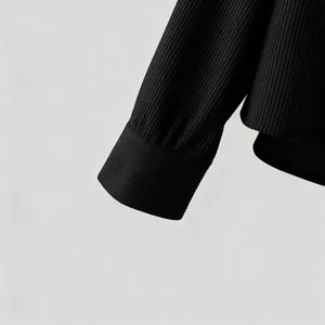 Gedetailleerde close-up van de geribbelde corduroy textuur op een zwarte overhemdmouw.