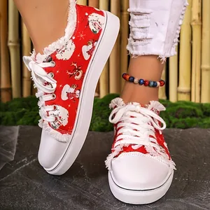 Close-up of festive red canvas shoes featuring Santa and reindeer prints with frayed edges