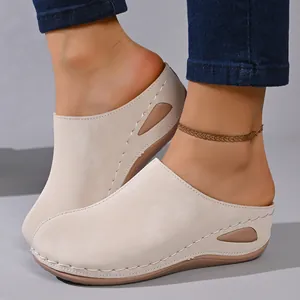 Detail view of beige wedge platform mules featuring elegant hand-stitched edging and side cutout.
