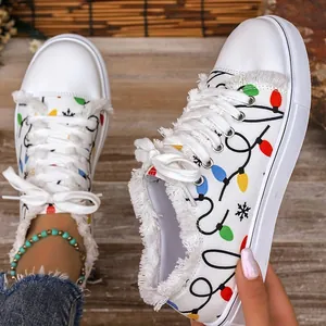 Close-up of white canvas sneakers with festive colorful bulb print and frayed edges