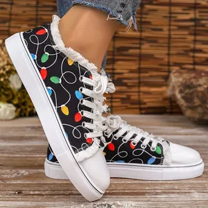 Detailed view of women's canvas shoes with colorful bulb print and frayed edges