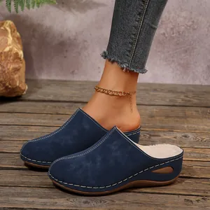Detailed view of warm blue closed-toe slippers with soft fur lining and white stitching