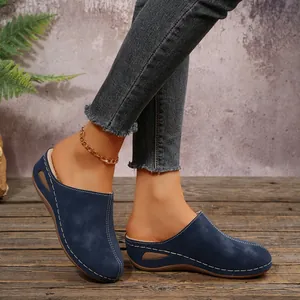 Close-up of women's navy blue warm fleece-lined slip-on clogs on a rustic wooden floor