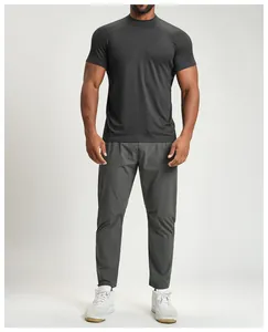 Fit man in black breathable athletic short sleeve t-shirt and grey outdoor pants outfit