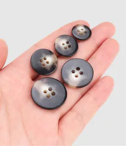 Detail view of four-hole urea buttons with natural marble pattern on hand.