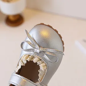 Close-up of silver girls' Mary Jane shoe with elegant bow and delicate lace detail