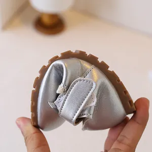 Detail showing the flexibility of silver soft-sole toddler walker shoes for little girls