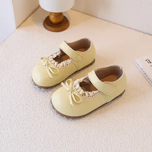 Detailed top-down view of yellow toddler princess shoes with lace edges and a bow.