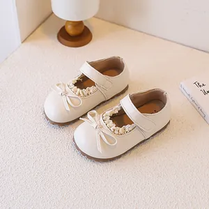 Detailed view of cream baby Mary Jane shoes with delicate lace and cute bow decor