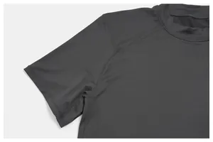 Detailed macro shot of the crew neckline and raglan sleeve on a grey sports t-shirt.
