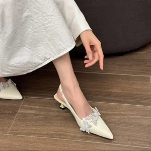 Close-up detail of cream pointed kitten heel slingbacks with sparkling rhinestone butterflies