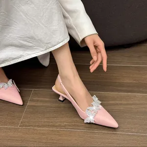 Detail view of elegant pink kitten heel slingbacks with rhinestone butterflies.