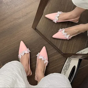 Elegant macro view of pink pointed-toe slingback high heels with rhinestone butterfly motifs