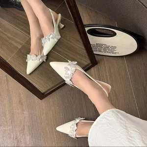 Close-up of elegant cream pointed-toe slingback heels with sparkling rhinestone butterflies