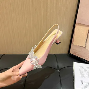 Close-up of elegant pink slingback heels featuring shimmering rhinestone butterfly decor.