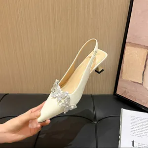 Detail of cream pointed-toe slingback heel with rhinestone butterfly decoration