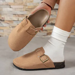Women's tan suede clog sandals with adjustable buckle strap and cork sole detail