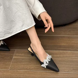 Close-up of black pointed-toe slingback heels with sparkling rhinestone butterflies