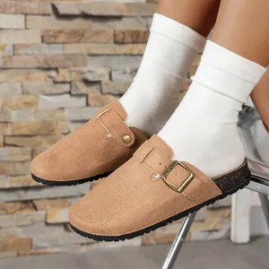 Detail of brown suede closed-toe clogs with adjustable buckle and cork sole