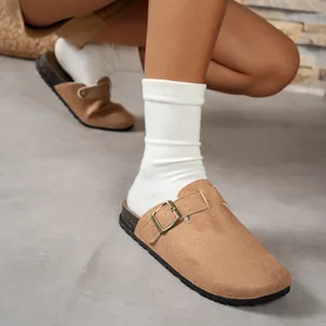 Detailed view of camel suede round-toe clogs with adjustable buckle strap and cork sole.