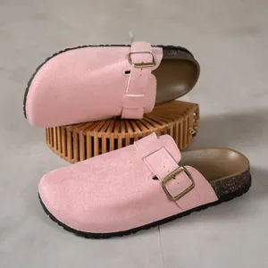 Close-up of pink suede round-toe clogs with adjustable buckle and cork sole