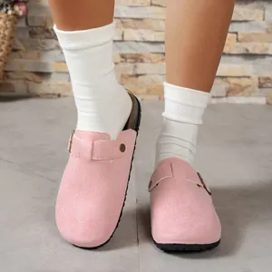 Detail shot of pink suede clogs paired with white socks in an indoor setting