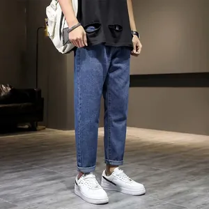 Nauwsluitende elastische heren spijkerbroek in 9/10 lengte met witte sneakers