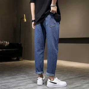 Zijaanzicht van een blauwe slim fit heren spijkerbroek met omgeslagen zoom en schoenen