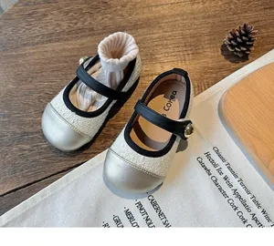 Elegant girls' Mary Jane shoes with textured fabric and metallic toe cap detail.