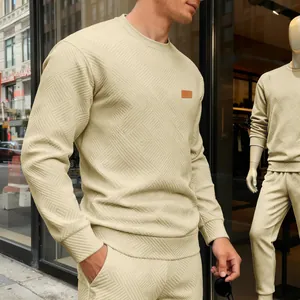 Detailansicht eines beigen Herren-Sweatshirts mit strukturiertem geometrischem Muster.